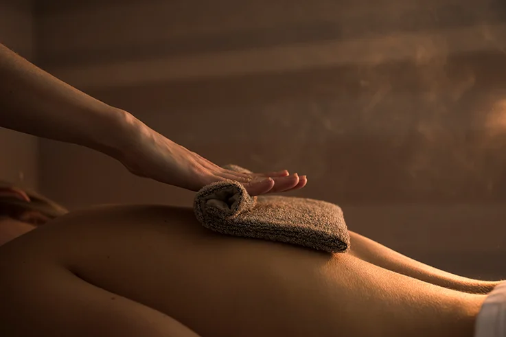 Tratamiento corporal relajante con toallas calientes sobre la espalda